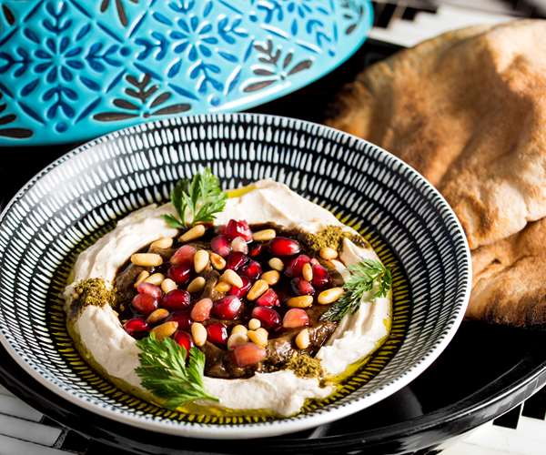 dish garnished with pine nuts and pomegranate