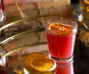 Red cocktail on mirrored table